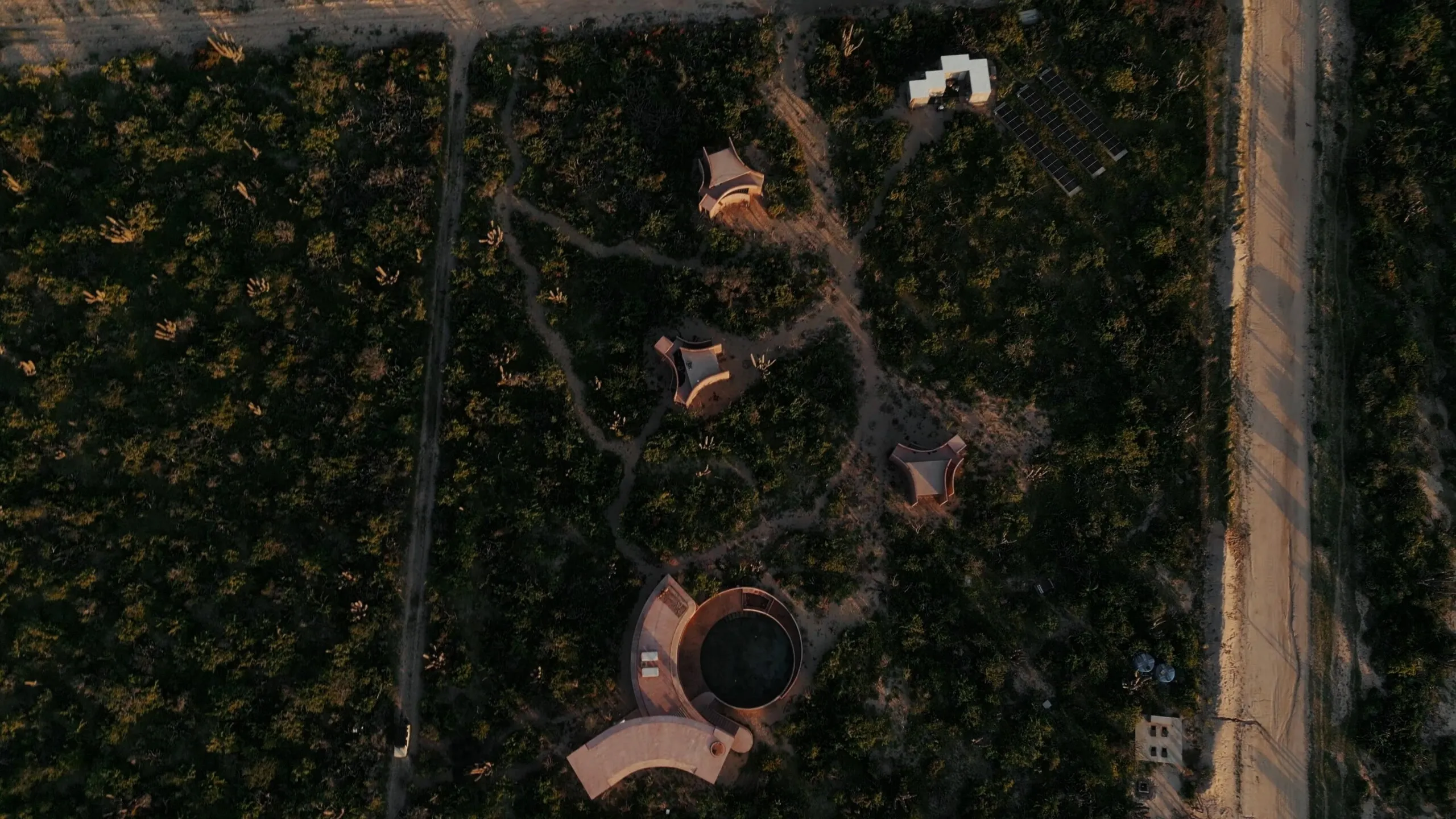 Aerial view of the Nereidas villa and infinity pool amid the Todos Santos desert, steps from the Pacific